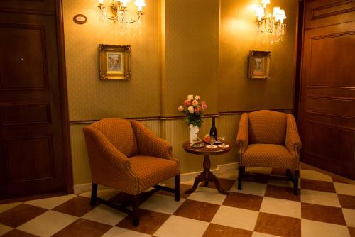 a waiting room with two chairs and a table with flowers at Grand Hotel Tepatitlán in Tepatitlán de Morelos