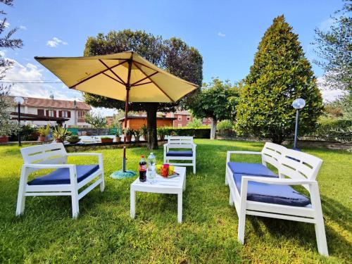 特爾尼的住宿－Villetta del Capriolo con giardino, vicino Centro，草上一组椅子和一把伞