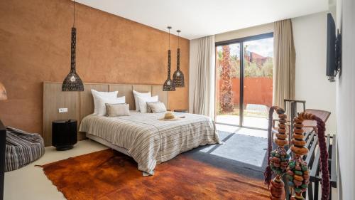 a bedroom with a bed and a large window at Villa M golf Amelkis à proximité in Marrakech