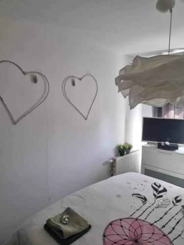 sypialnia z sercami na ścianie i łóżkiem w obiekcie Chez moi à côté du Groupama stadium w mieście Décines-Charpieu