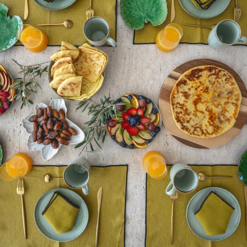 a table with a pizza and food on it at Villa Madjha Ecolodge Marrakech in Marrakech
