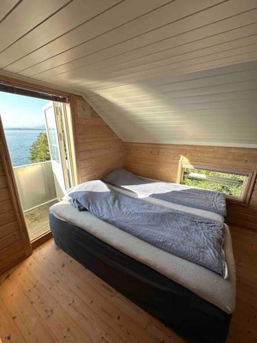 a bed in a small room with a window at Exclusive panorama view of the Oslofjord 