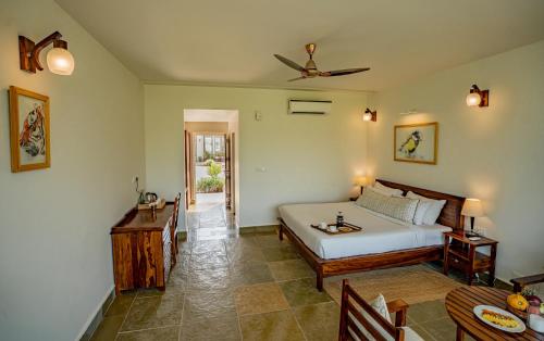 a bedroom with a bed and a table in it at Guldaar - A Luxury Forest Retreat in Tehla