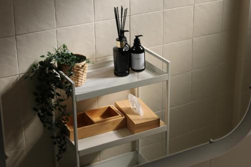 a shelf in a bathroom with bottles and plants at Policlinico Apartment in Rome