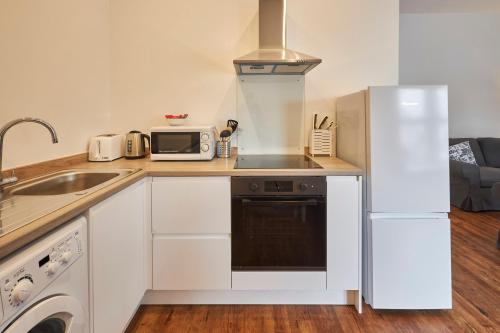 a kitchen with a white refrigerator and a microwave at Host & Stay - Main Street Apartments in Seahouses
