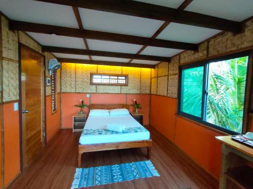 a small room with a bed and a window at Grandview Cottages Resort in Siaton