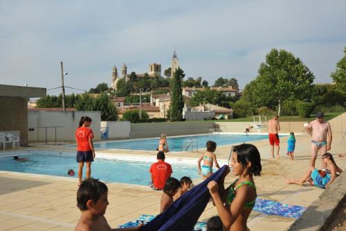 un groupe de personnes assises autour d'une piscine dans l'établissement Auberge de la Fontaine, à Rians