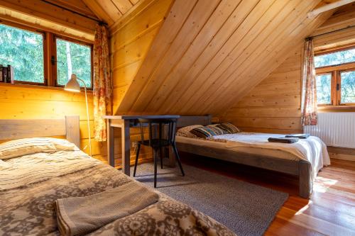 a bedroom with two beds and a desk in a cabin at Dom Suwalszczyzna in Suwałki