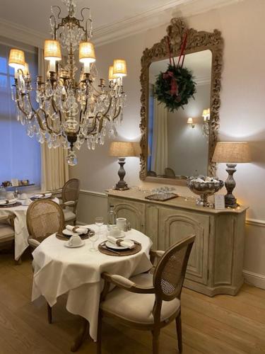 a dining room with a table and a mirror at Mansion9Bruges in Bruges