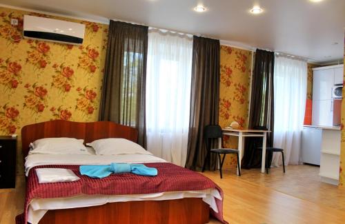 Un dormitorio con una cama con una corbata azul de moño. en Бодрум, en Petropavlovsk