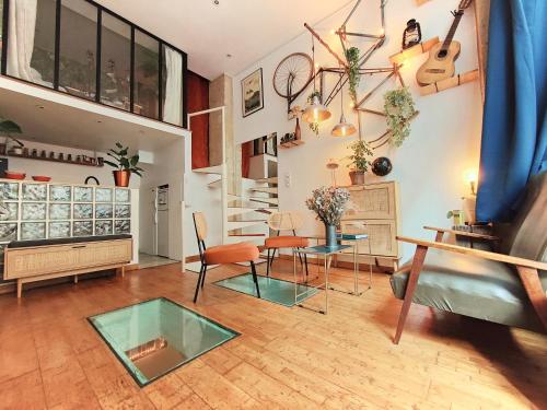 un salon avec une table en verre et des chaises dans l'établissement Unique MontmartreSacré-Cœur appartement Parking, à Paris