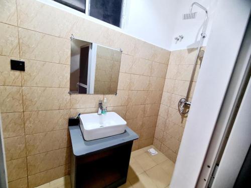 uma casa de banho com um lavatório e um espelho em A Gorgeous Condo with a kingsize bed em Dar es Salaam