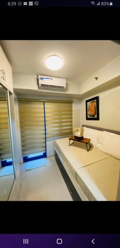um quarto com duas camas e uma mesa em 429A Sea Residences em Manila