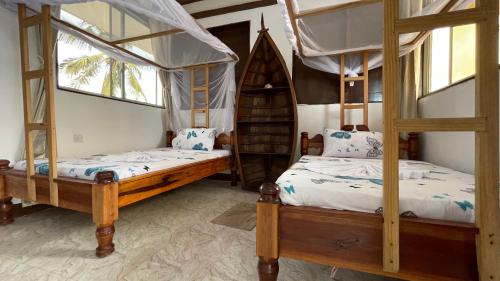 a bedroom with two bunk beds and a window at Aquarium Beach House in Nungwi