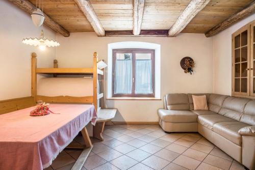 uma sala de estar com um sofá e um beliche em Casa Delmarco em Castello di Fiemme