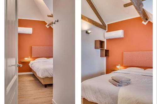 two beds in a room with orange walls at La Dominotte Arcen in Arcen