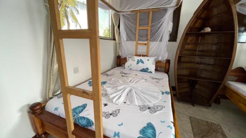 a bedroom with a bunk bed with a ladder at Aquarium Beach House in Nungwi