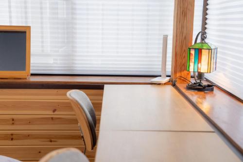 a desk with a lamp and a computer on it at Marushige in Nozawa Onsen