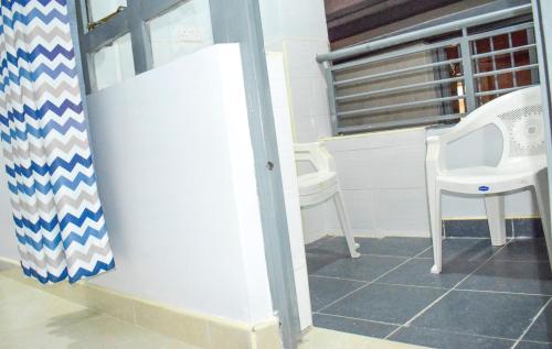 Zimmer mit einem weißen Stuhl und einem Fenster in der Unterkunft One Bedroom BnB in Thika Town7 in Thika