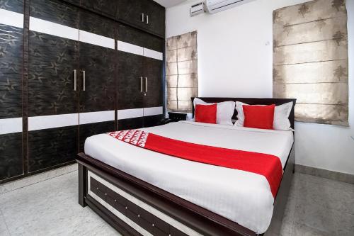 a bedroom with a large bed with red pillows at OYOFlagship Hillside Hotel Kukatpally in Kukatpally