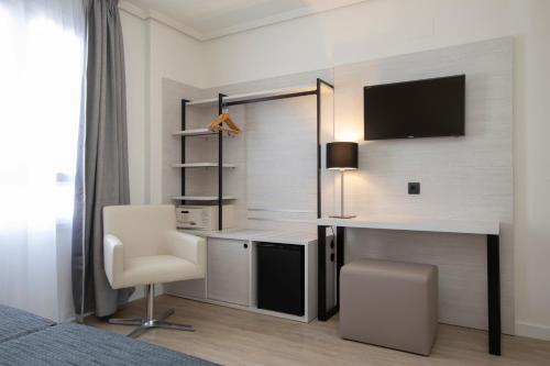 a bedroom with a desk with a computer and a chair at Porcel Ganivet in Madrid