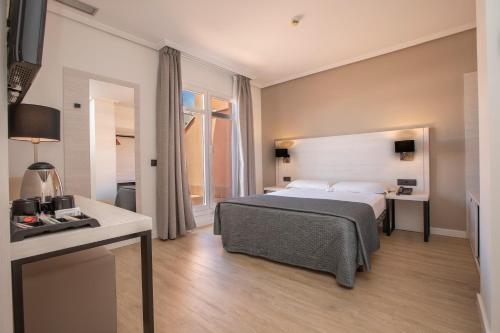 una camera d'albergo con letto e scrivania di Porcel Ganivet a Madrid