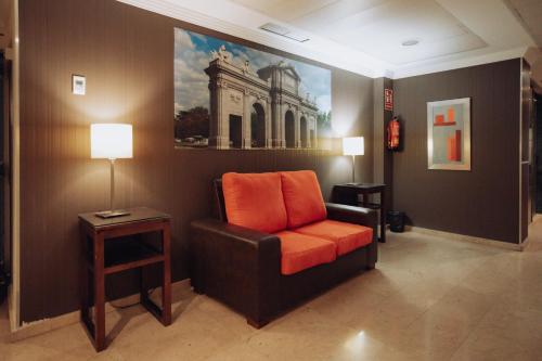 a living room with a chair and a painting on the wall at Porcel Ganivet in Madrid
