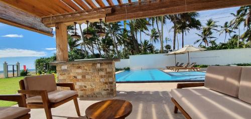an outdoor patio with a pool and a table and chairs at Aryan Beach Villa in Wadduwa