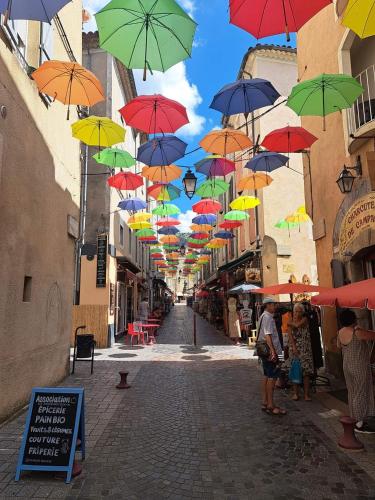 a bunch of umbrellas hanging over a street at Tiny house cosy in Anduze