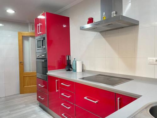 een keuken met rode kasten en een rode koelkast bij Apartamento en Arahal Sevilla in El Arahal