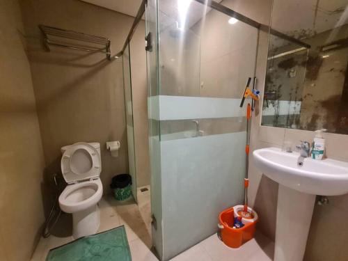 a bathroom with a shower and a toilet and a sink at 2BR El Royale Apartement Braga in Bandung