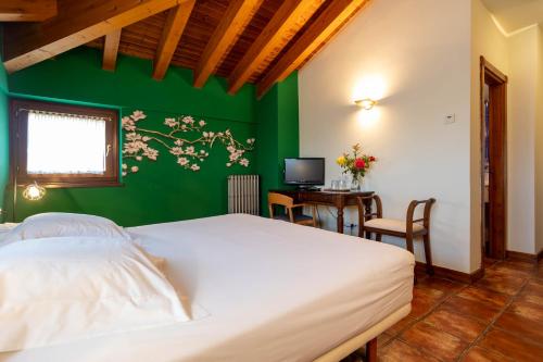 a bedroom with a bed and a desk with a computer at Hotel Villa de Ábalos in Ábalos