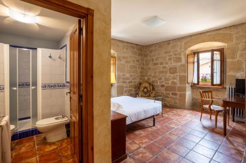 a bedroom with a bed and a bathroom at Hotel Villa de Ábalos in Ábalos