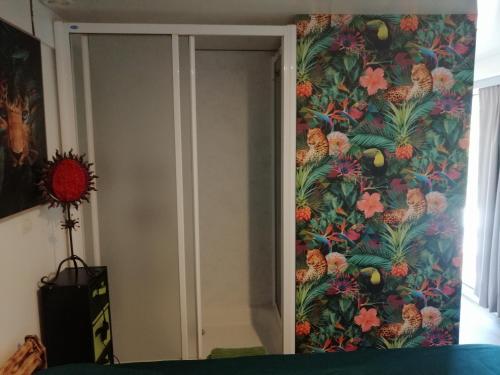 - une chambre avec un papier peint tropical sur le mur dans l'établissement Tiny house cosy, à Anduze