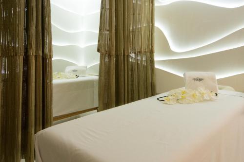 a white bed with flowers on top of it at Grand Hotel Tepatitlán in Tepatitlán de Morelos