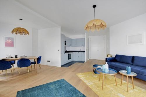 a living room with a blue couch and a table at Drawing House in Paris