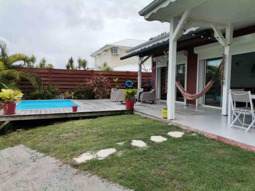 哥西爾的住宿－Villa cosy toute équipée avec piscine，一个带游泳池和房子的后院