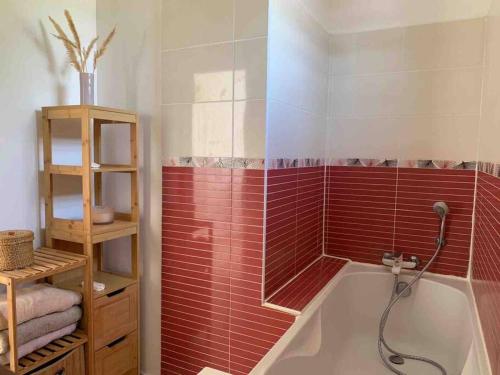 y baño con bañera y azulejos rojos. en Villa cosy toute équipée avec piscine en Le Gosier