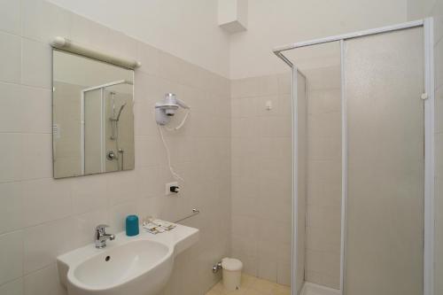 a white bathroom with a sink and a shower at VILLARTE in Agliana