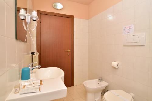 La salle de bains est pourvue de toilettes blanches et d'un lavabo. dans l'établissement VILLARTE, à Agliana