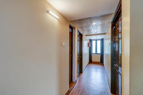 um corredor com pisos de madeira e um corredor com portas em OYO Flagship M H Grand em Nalmatha