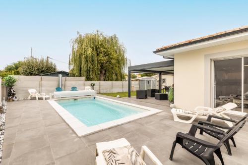 une arrière-cour avec une piscine, des chaises et une maison dans l'établissement Villa bassin d´archachon, à Arès