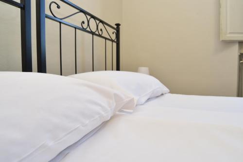 a bedroom with two white beds with white pillows at VILLARTE in Agliana