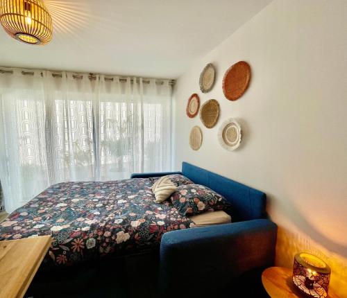a bedroom with a blue bed and a window at Studio le petit écureuil in Carnac