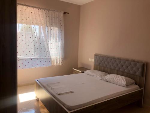 ein Schlafzimmer mit einem großen Bett mit Fenster in der Unterkunft Center Apartment in Vlorë