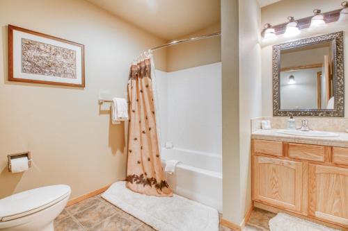 a bathroom with a toilet and a sink and a tub at Icicle Village Resort 507: Alpenglow Condo in Leavenworth