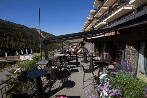 a patio with tables and chairs on a building at Hotel Piolets Soldeu Centre by Nexta in Soldeu