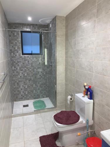 a bathroom with a shower and a toilet with a window at 1-BR Gem Near GTC, Westlands 5G in Nairobi