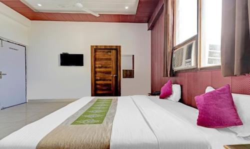 um quarto grande com uma cama grande e almofadas cor-de-rosa em Hotel P.S. Villa em Agra