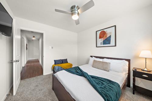 a bedroom with a bed and a ceiling fan at Pool Home Nr Heights, Dt Games Wifi Bbq Yard in Houston